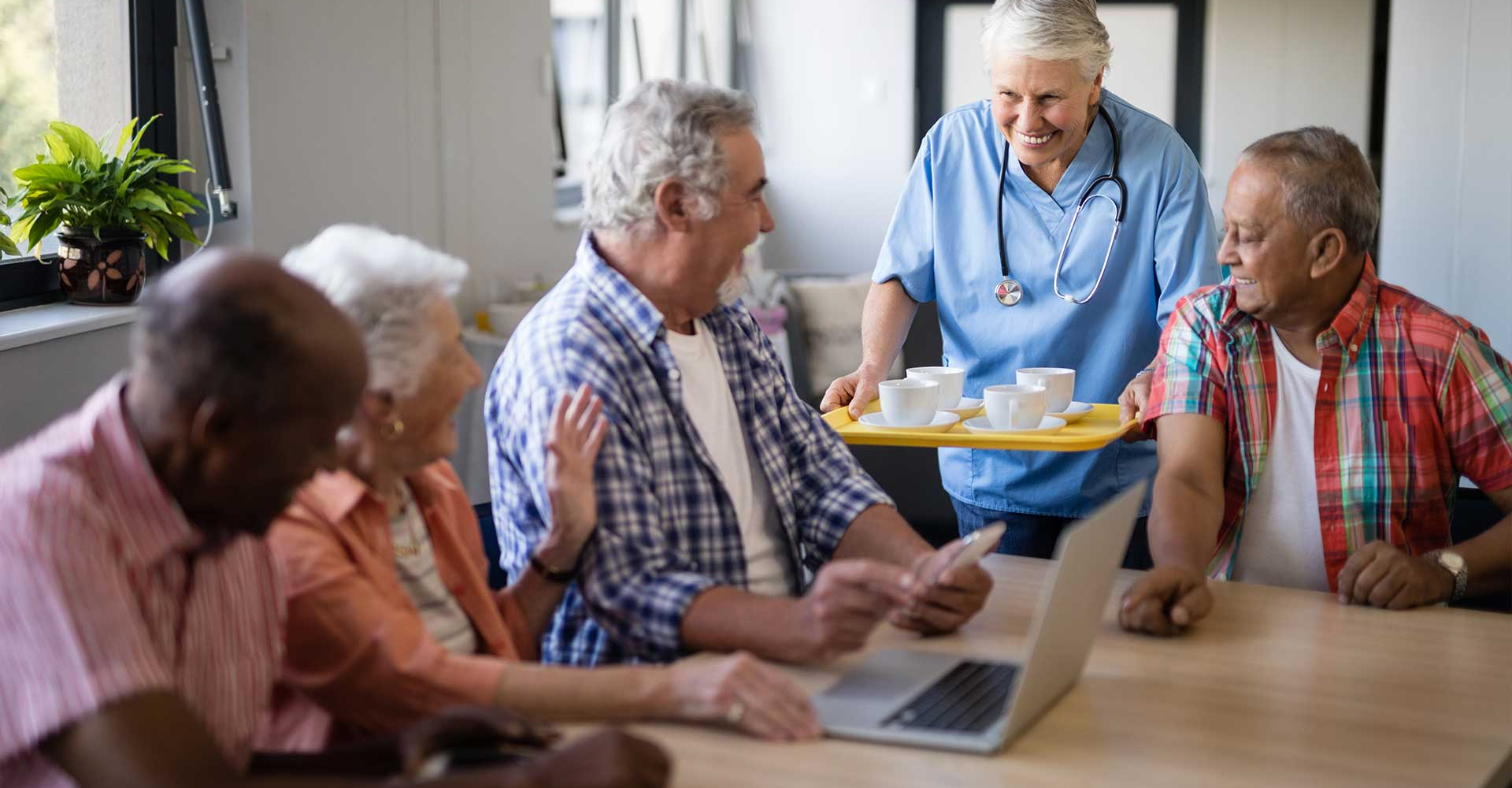 smiling-healthcare-worker-serving-coffee-to-senior-3KJ8LMX.jpg
