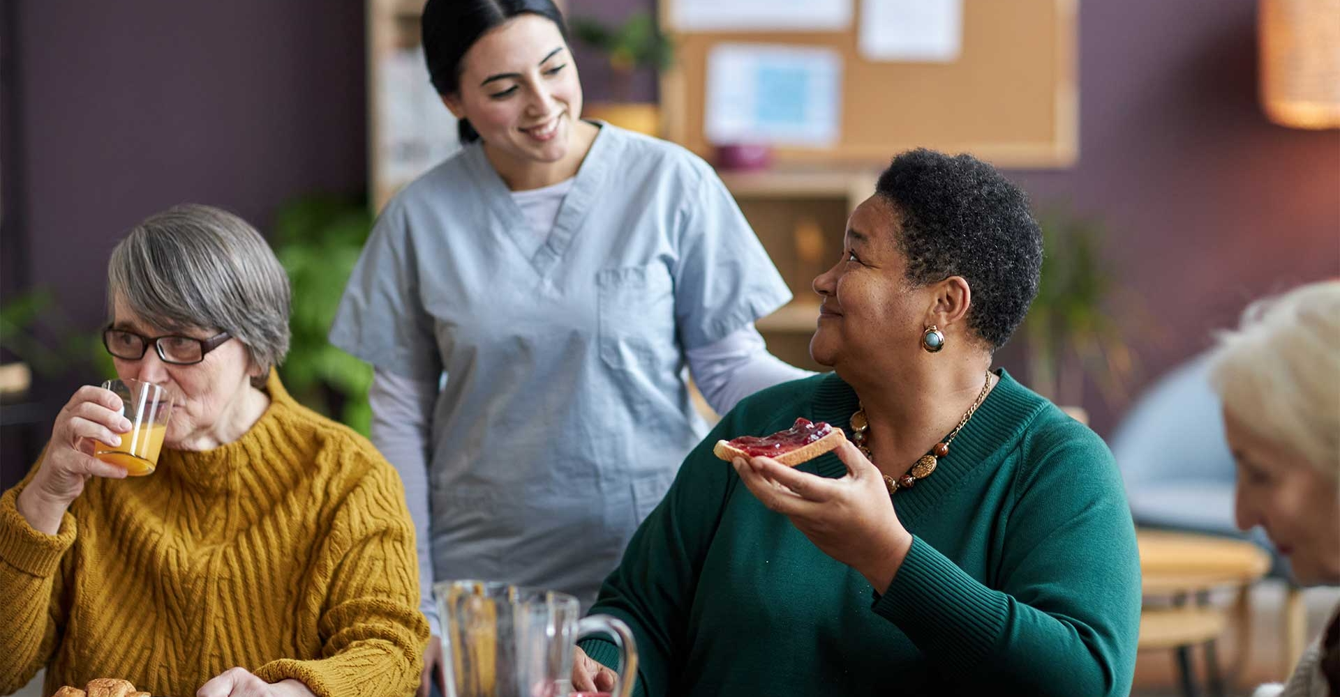 young-nurse-assisting-senior-people-during-breakfa-V26QWH7.jpg