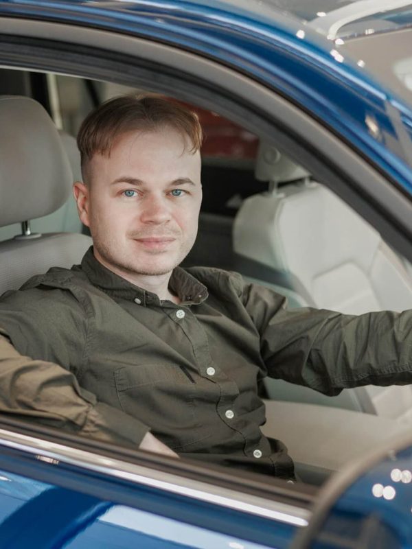 happy-man-is-sitting-in-a-blue-car-in-a-car-dealership-a-man-buys-a-car-at-a-car-dealership.jpg