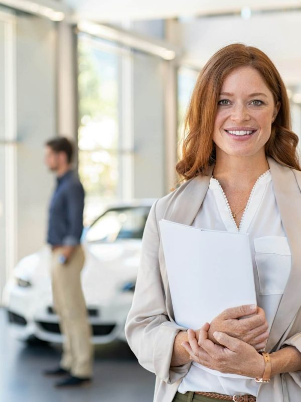 satisfied-saleswoman-in-car-dealership.jpg