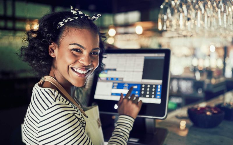 smiling-african-waitress-using-a-restaurant-point-of-sale-terminal-1.jpg