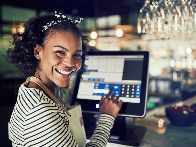 smiling-african-waitress-using-a-restaurant-point-of-sale-terminal-1.jpg