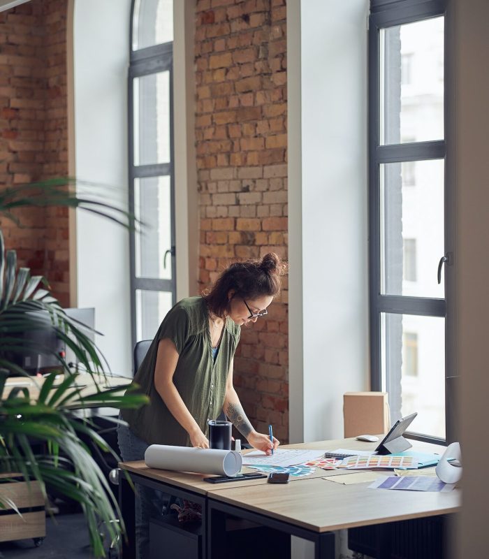 interior-designer-or-architect-in-casual-wear-with-messy-hairdo-looking-focused-while-working-on.jpg