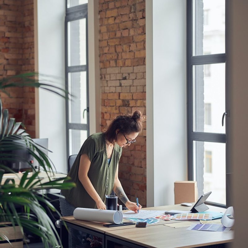 interior-designer-or-architect-in-casual-wear-with-messy-hairdo-looking-focused-while-working-on.jpg